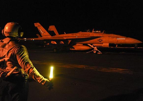 Истребитель F/A-18F Super Hornet 211-й истребительно-бомбардировочной эскадрильи приготовился к ночному старту с палубы авианосца USS Theodore Roosevelt, фото сделано 2 октября 2015 года в Аравийском заливе.
