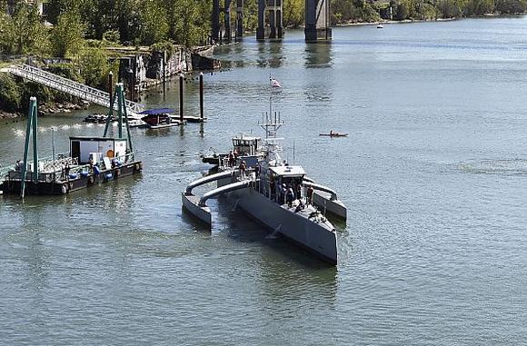 Sea Hunter, головной прототип проекта Агентства DARPA ACTUV (противолодочное безэкипажное судно большой автономности), отправляется на испытания после завершения церемонии крещения, фото сделано 7 апреля 2016 года в Portland, шт. Орегон. 
