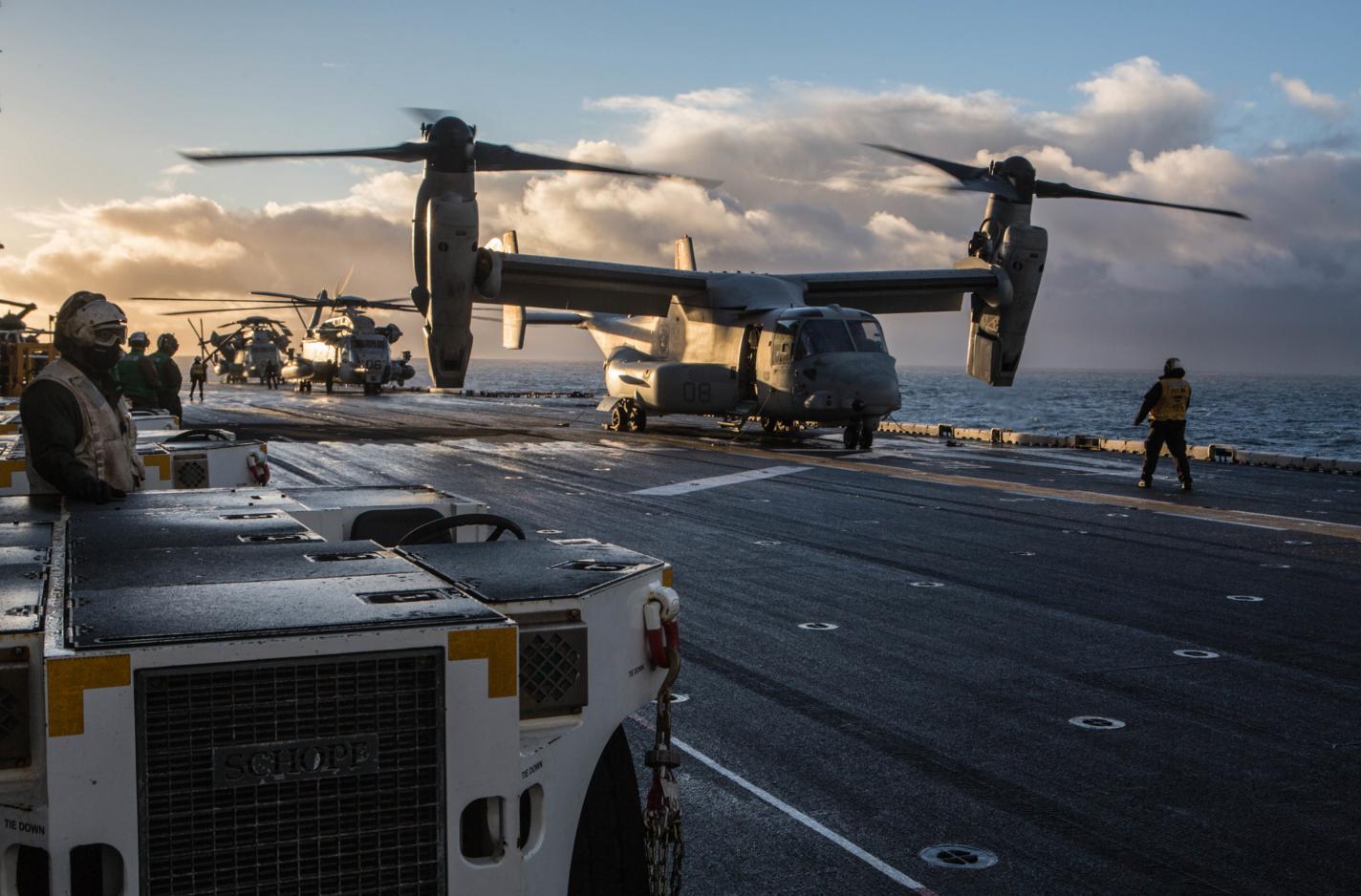V-22 Osprey и CH-53 Sea Stallion готовятся к взлету с палубы универсального десантного корабля  USS Iwo Jima для высадки десанта в специальной зоне в районе АБ Keflavik, Исландия, фото сделано 17 октября 2018 года в Северной Атлантике (Iwo Jima и размещенные на нем подразделения 24-й экспедиционной бригады американской морской пехоты готовятся к участию в учении Trident Juncture 2018)
